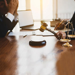 Scene in a courtroom showing a lawyer standing in front of a judge with a gavel.